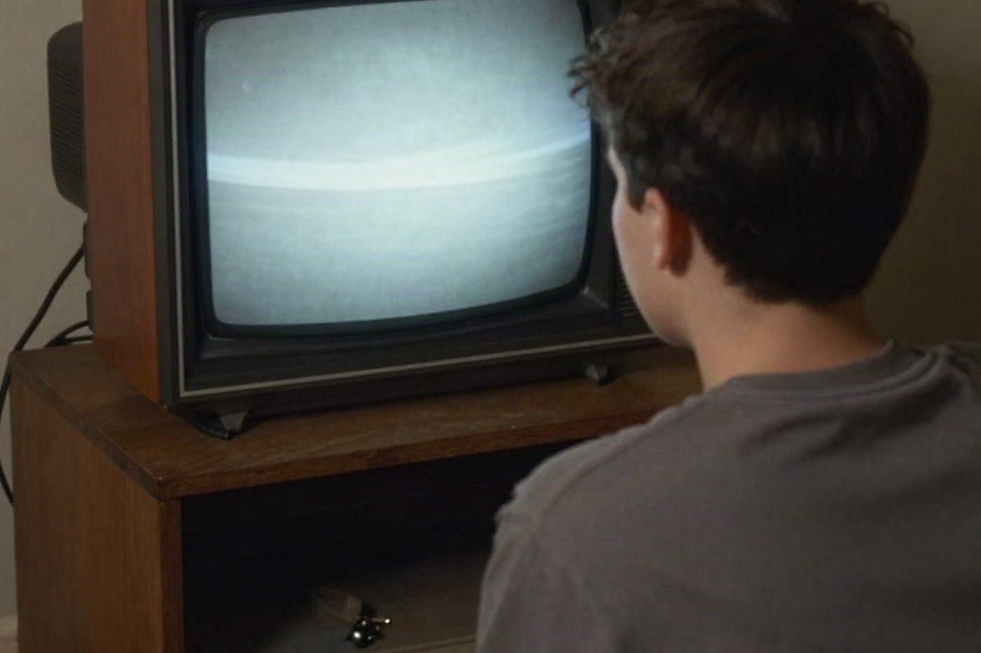 Nastolatek ogląda reklamę w telewizorze kineskopowym w pokoju z lat dziewięćdziesiątych